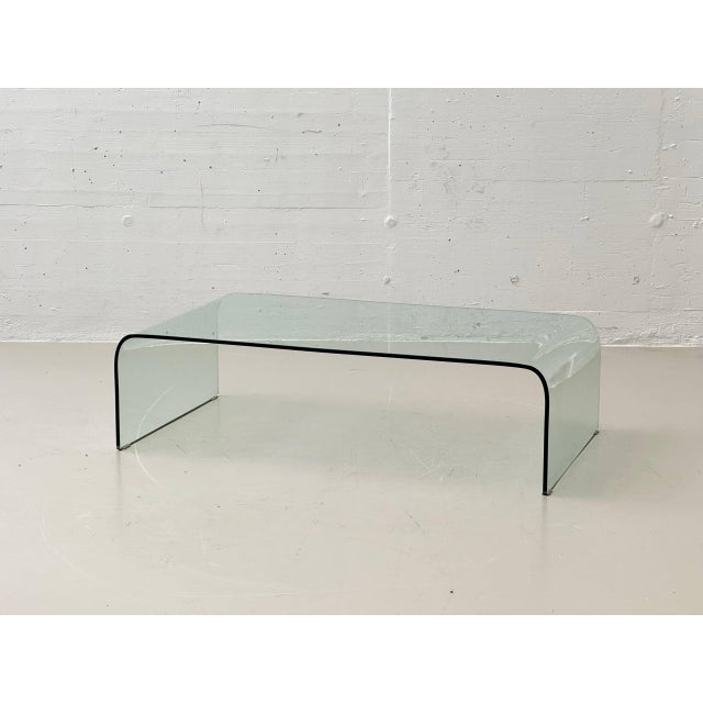 A timeless coffee table crafted from solid, clear glass, featuring a minimalist, architectural design. The single-piece...