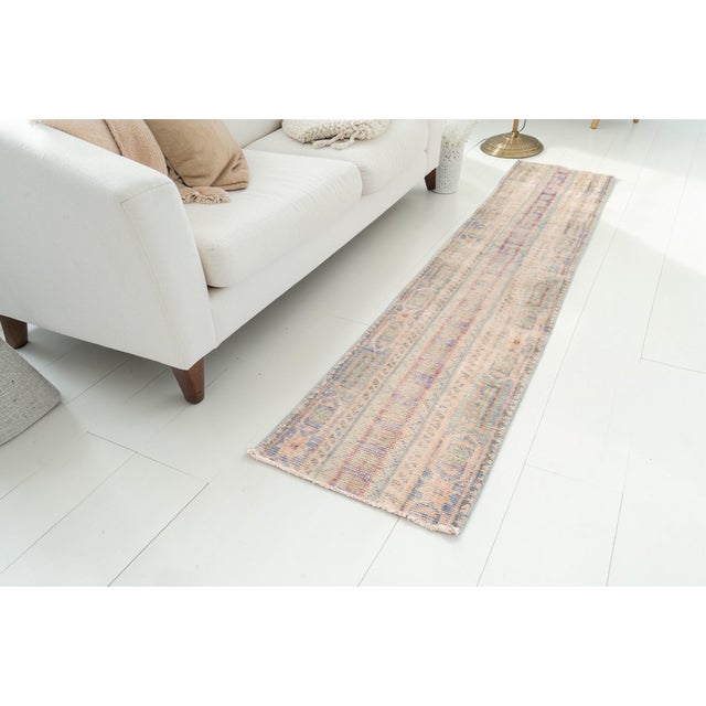 This is a vintage Turkish Oushak rug from the Mid 20th Century. The piece was hand-knotted.