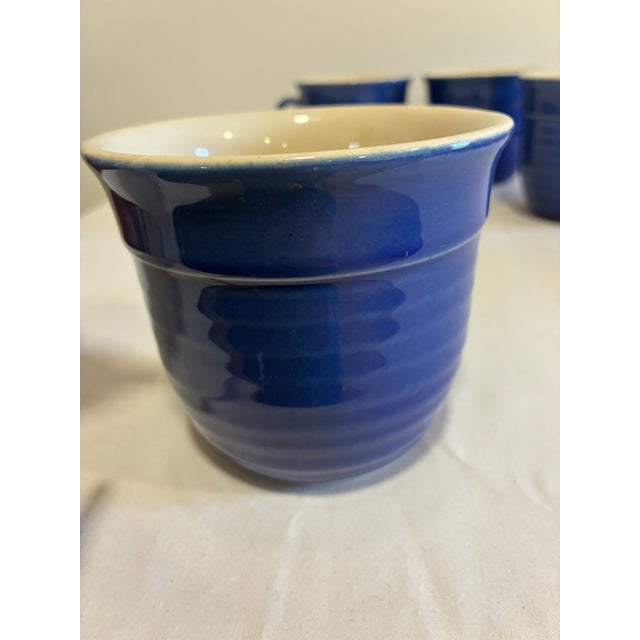 This set of 4 mugs by Emile Henry, France, showcases the same rich cobalt blue glaze and ribbed detailing found in their...