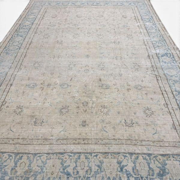 This elegant antique Kirman rug features a delicate allover composition of fine floral motifs set against a soft ivory...