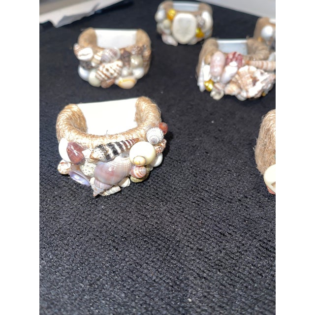 Quality set of 12 napkin rings. Each ring is encrusted with a unique combination of miniature seashells. The porcelain...