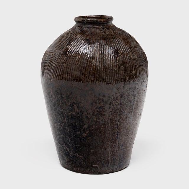 This large ceramic jar is a vintage Chinese wine vessel from the early 20th century, originally used for aging wine and...
