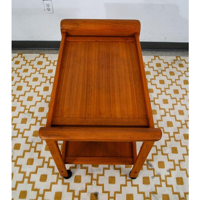 High quality rolling teak bar cart by Sun Cabinet Co. Comes with 2 large surfaces in teak and solid teak handles / frame....