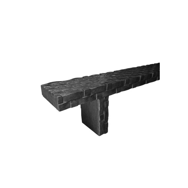 A sculptural hand-carved mango wood bench. To achieve is rich black pigment the bench was burnt three times and then...