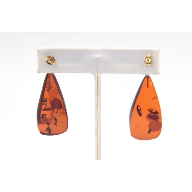 Pair of tear drop shaped amber with star spangled inclusions hanging from 14k gold balls. To wear you must have pierced...