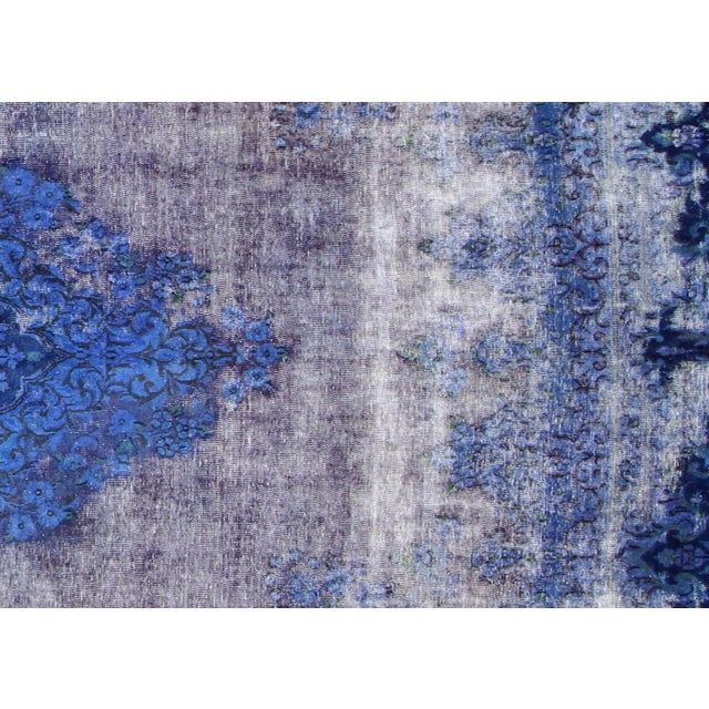 This vintage Persian Kerman Overdyed Rug, measuring 9'7" x 12'8", is handwoven with wool on a cotton foundation in Iran....