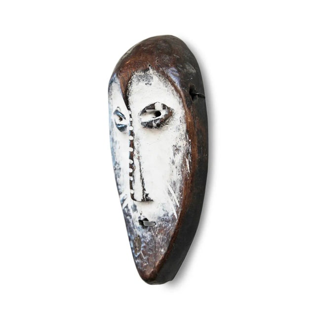 Original vintage Lega tribal mask from Democratic Republic of the Congo. White clay on face contrasts with rich brown...