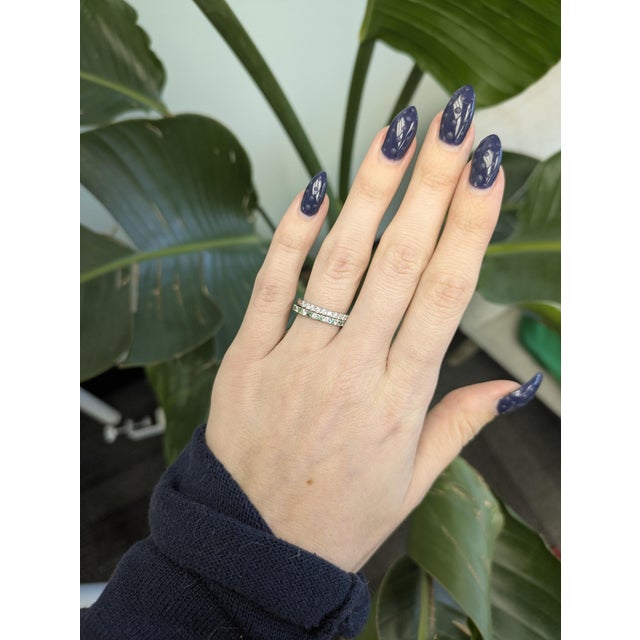 Crafted in solid 14K white gold, this elegant stackable band features a refined mix of natural green and white diamonds...