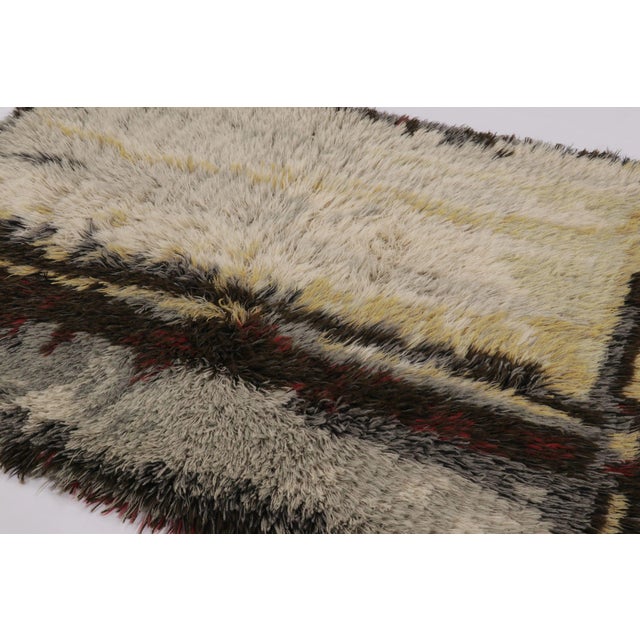 Hand-knotted in lush, high-pile wool in Sweden circa 1960-1970, this 4x6 vintage Swedish Rya rug is a bold new addition to...