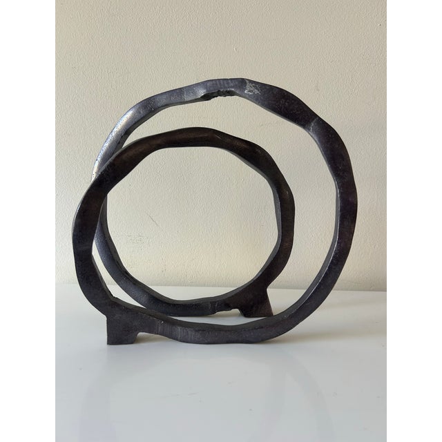 Solid aluminum sculpture with gunmetal-black finish, intertwined circle design with flowing organic vibe. The abstract...