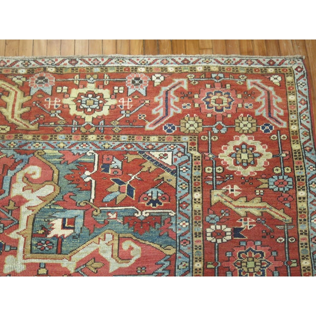 An early 20th Century Oversize Persian Heriz rug with a medallion and border design on a camel mustard ground....