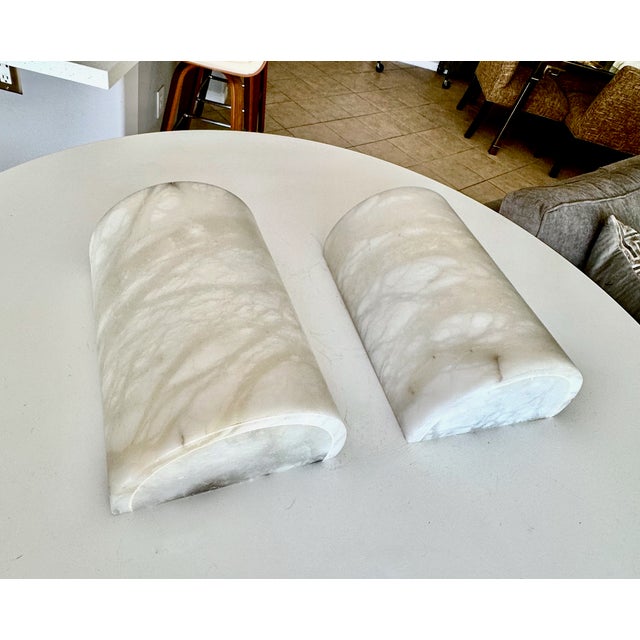 Pair of alabaster half cylinder shape minimalist wall sconces on crome plated backplates. Newly wired, uses candelabra...