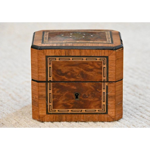 This antique octagonal tea caddy is crafted in richly figured burlwood veneer with refined contrasting stringing and...