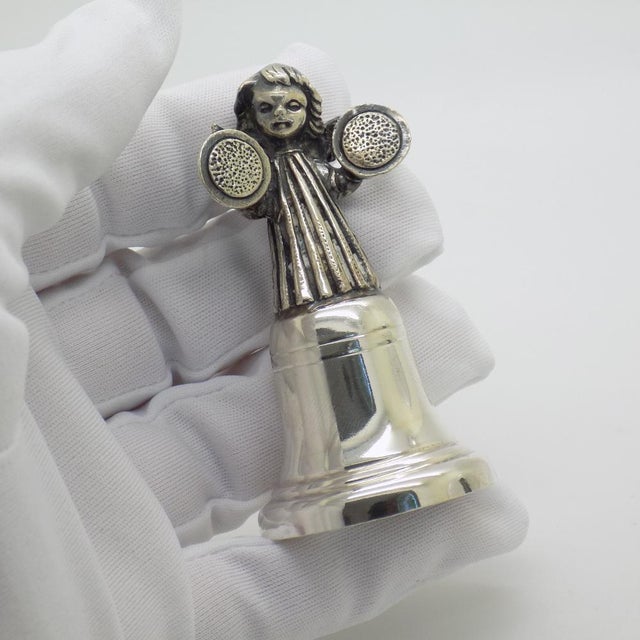 A vintage object in the form of a bell with an angel playing a musical instrument, crafted in florence, italy between the...