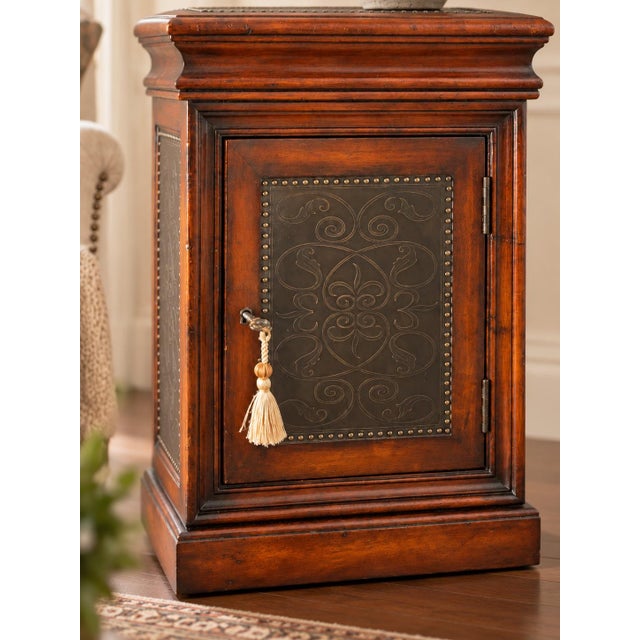 This distinctive solid-wood cabinet combines richly toned woodwork with beautifully engraved metal panels for an unusually...