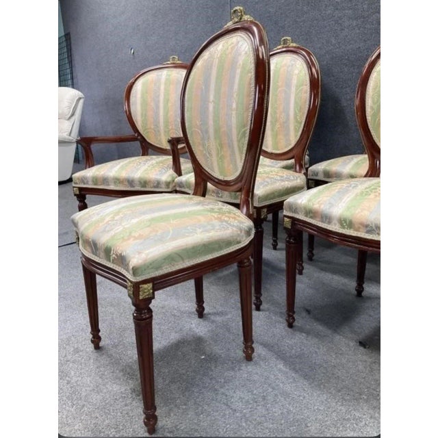 A hard to find set of 8 vintage Louis XVI style oval back dining chairs with hand cast brass cartouches and brass...