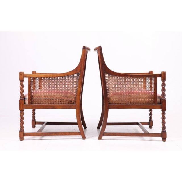 These two bergère chairs from the 1940s were designed and produced in Denmark. The chairs feature stained beechwood...