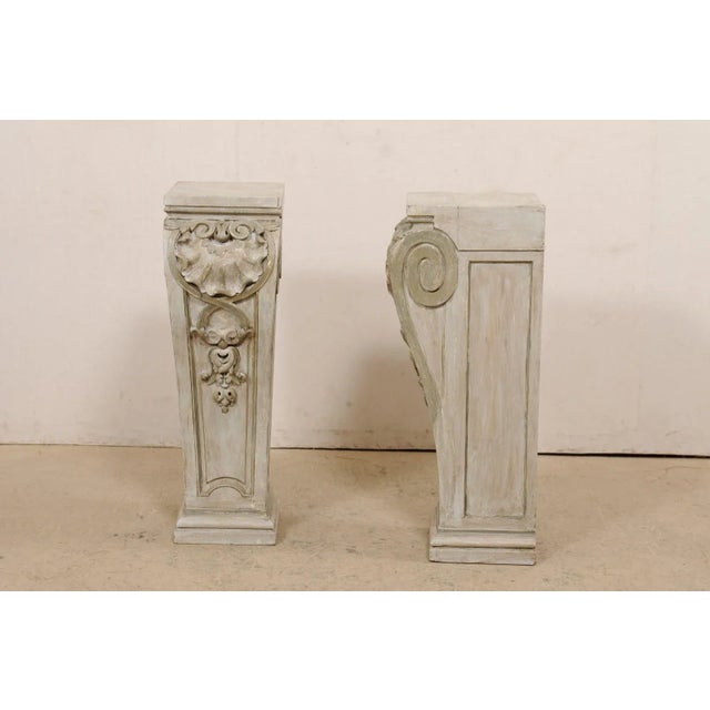 A pair of American carved-wood pedestals from the early 20th century. This antique pair of pedestals have been carved in a...