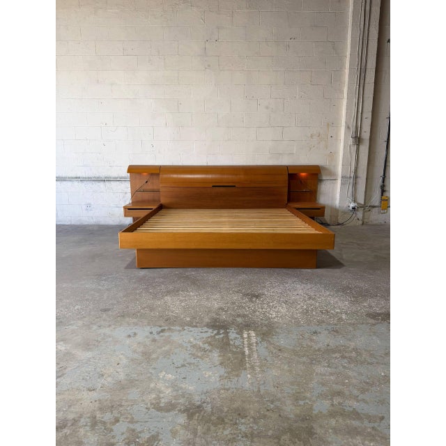 This platform bed features a curved headboard with a hidden top-loading storage compartment. Integrated panels host...