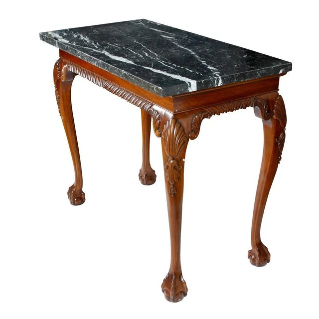 Elegant George III style walnut console table featuring a richly carved apron and cabriole legs terminating in ball-and-...
