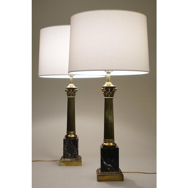 A bold and impressive matched pair of vintage Neoclassical Modern Brass & Marble stylized Corinthian Column table lamps...
