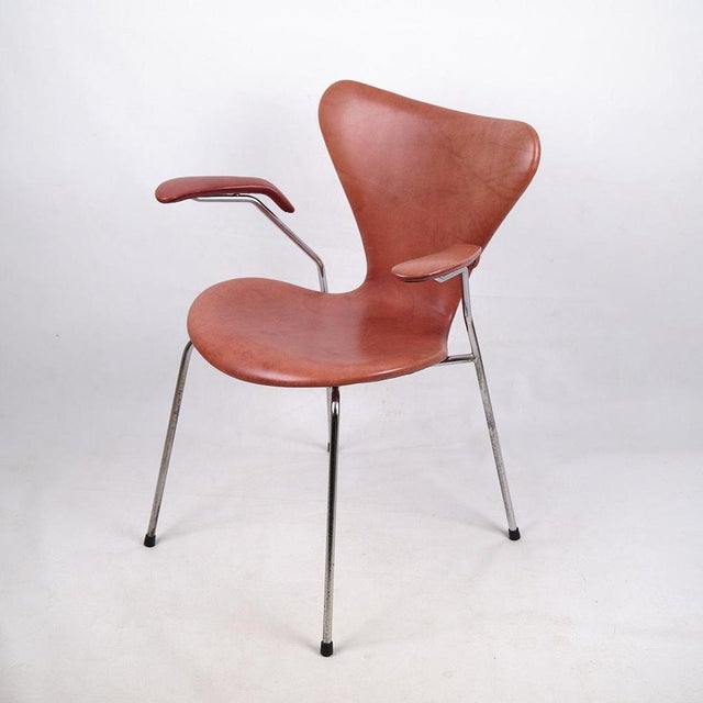 Arne jacobsen seven-chair with armrests, model 3207. Cognac-colored leather and chrome frame. Fritz hansen design classic....