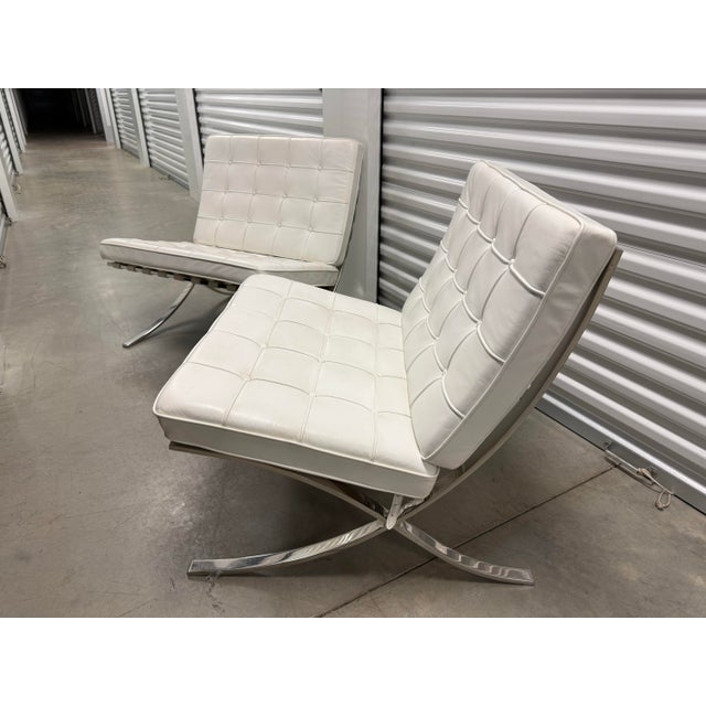 Pair of Knoll white leather Barcelona chairs with chrome base.