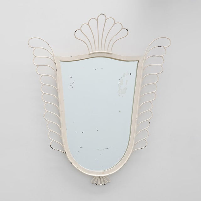 A charming French wall mirror from the 1950s, distinguished by its elegant shield-shaped form and airy decorative...