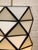 A striking pair of vintage hanging pendant lights featuring faceted geometric shades composed of milky white glass panels...