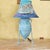 Striking coastal-inspired table lamp featuring a textured turquoise-blue ceramic amphora base with twin handles, a...