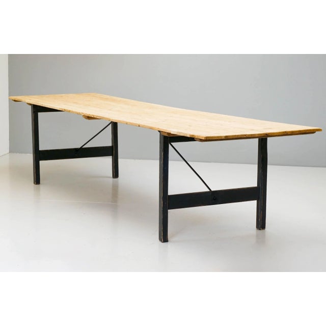 Large pine trestle table on folding legs.