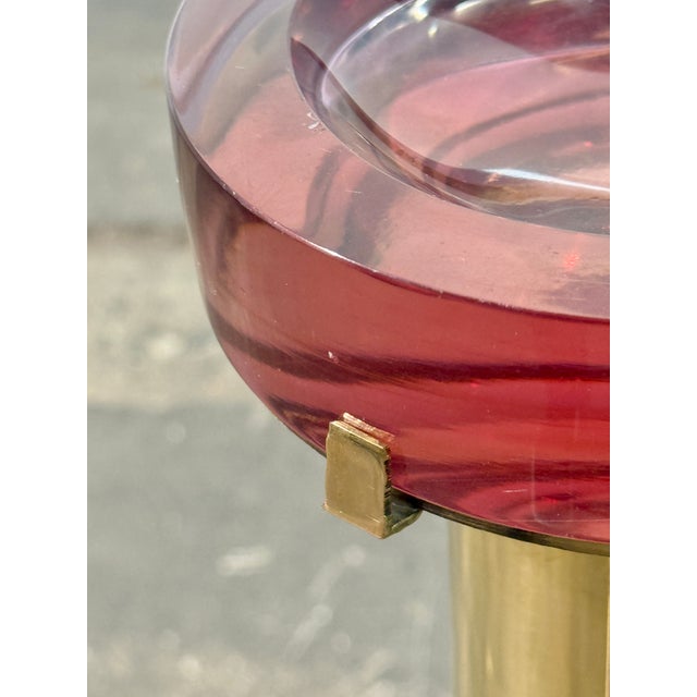 Striking Italian floor-standing ashtray from the 1970s, featuring a polished brass column and a substantial circular red...
