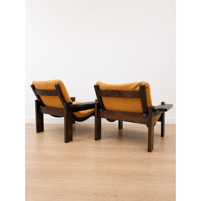 A pair of armchairs with a distinctive Scandinavian design from the 1970s. They feature a sturdy dark oak frame and a...