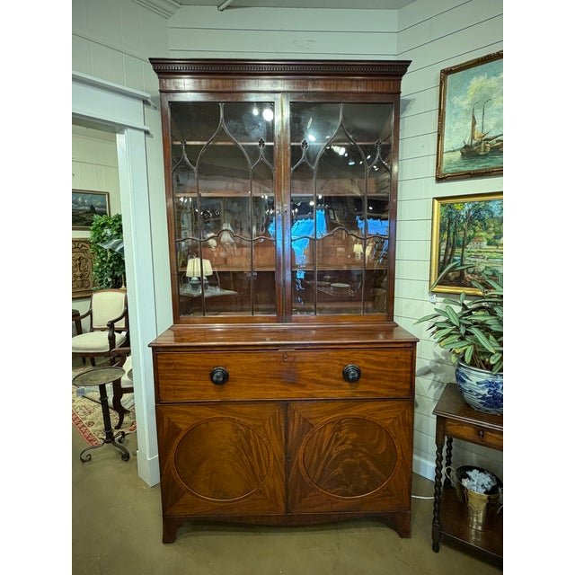 This is a beautiful English secretary bookcase with extended desk. The upper glass front doors are original to the piece....