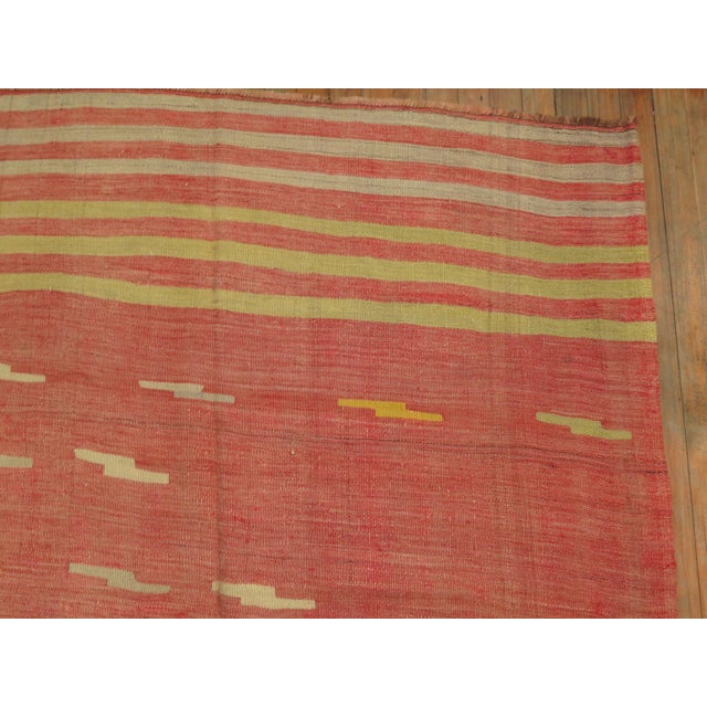 A room size midcentury handwoven predominantly melon red color Turkish flat-weave. The motif on this piece is somewhat...