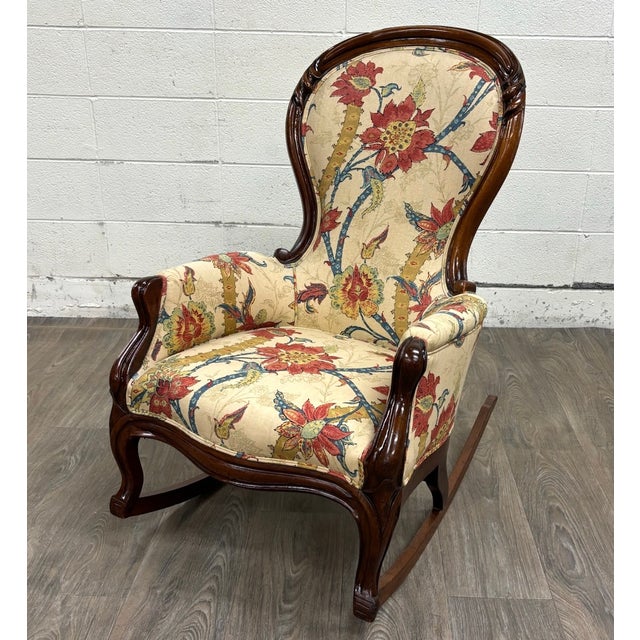 This is a stunning antique Victorian style walnut rocking chair featuring a tall balloon back, richly carved and molded...