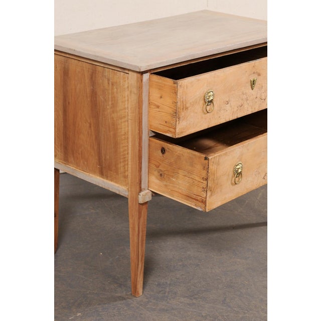 An Italian bleached and painted wood raised chest of two drawers from the 19th century. This antique cassettiera (chest of...