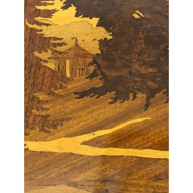 Marquetry Picture This gorgeous piece is made of different woods. The piece is varnished/laquered. There is an area on the...
