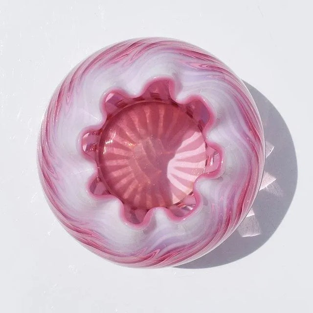 A beautiful art deco flashed cranberry flower vase. Created from art glass, this vase is round and features pink and white...