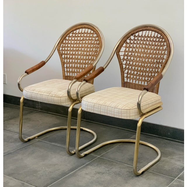 A pair of vintage 1970s cantilevered chrome and wicker armchairs made by over a century old company Bassett Mirror Co....