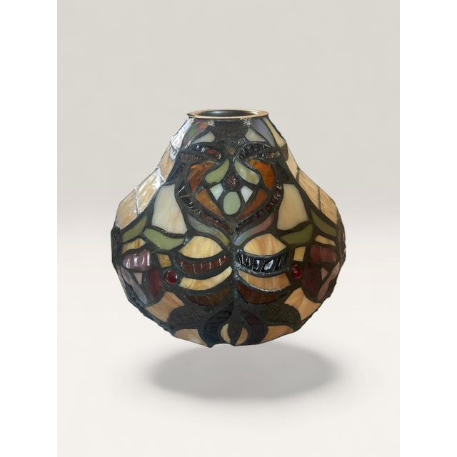 Beautiful pair of Tiffany-style stained glass pendant light shades featuring a warm, earthy color palette with floral and...