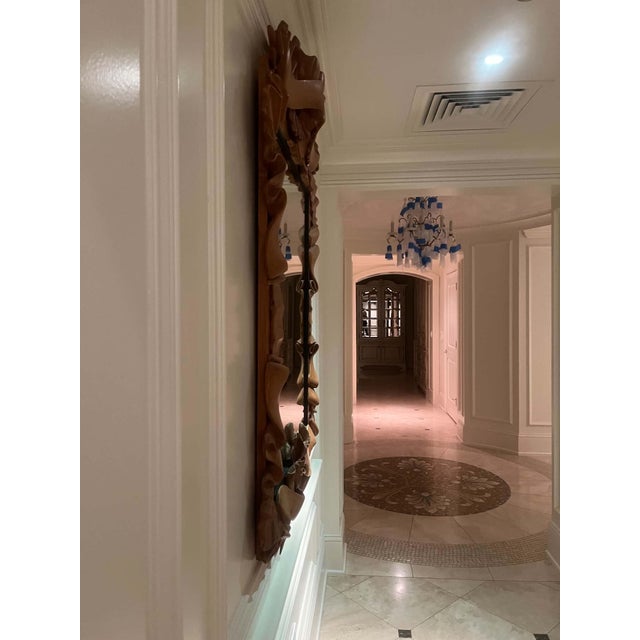 An exquisite carved wood mirror featuring a dramatic ribbon‑form surround, sculpted in deep folds that create movement,...