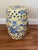 A glazed ceramic garden stool with cobalt blue chinoiserie decoration against a warm yellow ground. Birds, flowering...