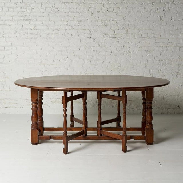 A beautifully crafted 1960s Belgian oak gate-leg table, combining timeless form with everyday versatility. Featuring the...