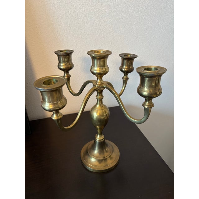Elegant vintage brass candelabrum crafted in India, featuring five gracefully curved arms surrounding a turned central...