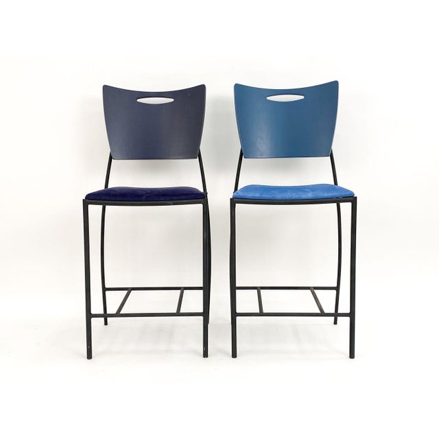 Wrought iron frames with multi-colored painted backrests and matching suede cushions. Labeled underneath and made circa...