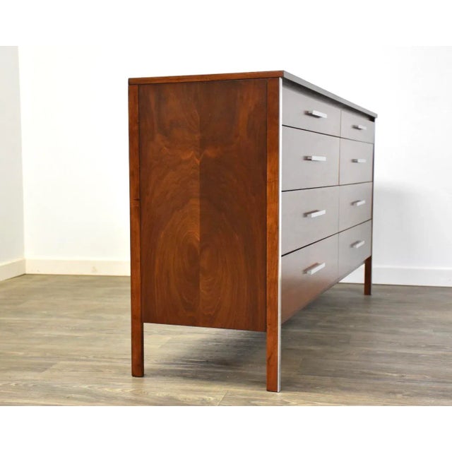 A mid century modern walnut long dresser with aluminum accents designed by Paul McCobb for Calvin Furniture. This dresser...