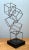 Showcasing dynamic modernist geometry and an open wireframe structure, this vintage mid-century sculpture features a...