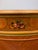 Elegant vintage Neoclassical demilune chest featuring richly figured wood veneer, decorative gilt accents, fluted...
