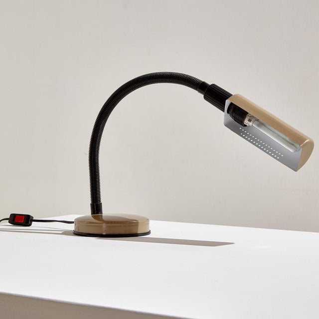 Veneta Lumi table lamp: a true Italian space age piece from the 1970s. The lamp has a metal base and lampshade, and an...